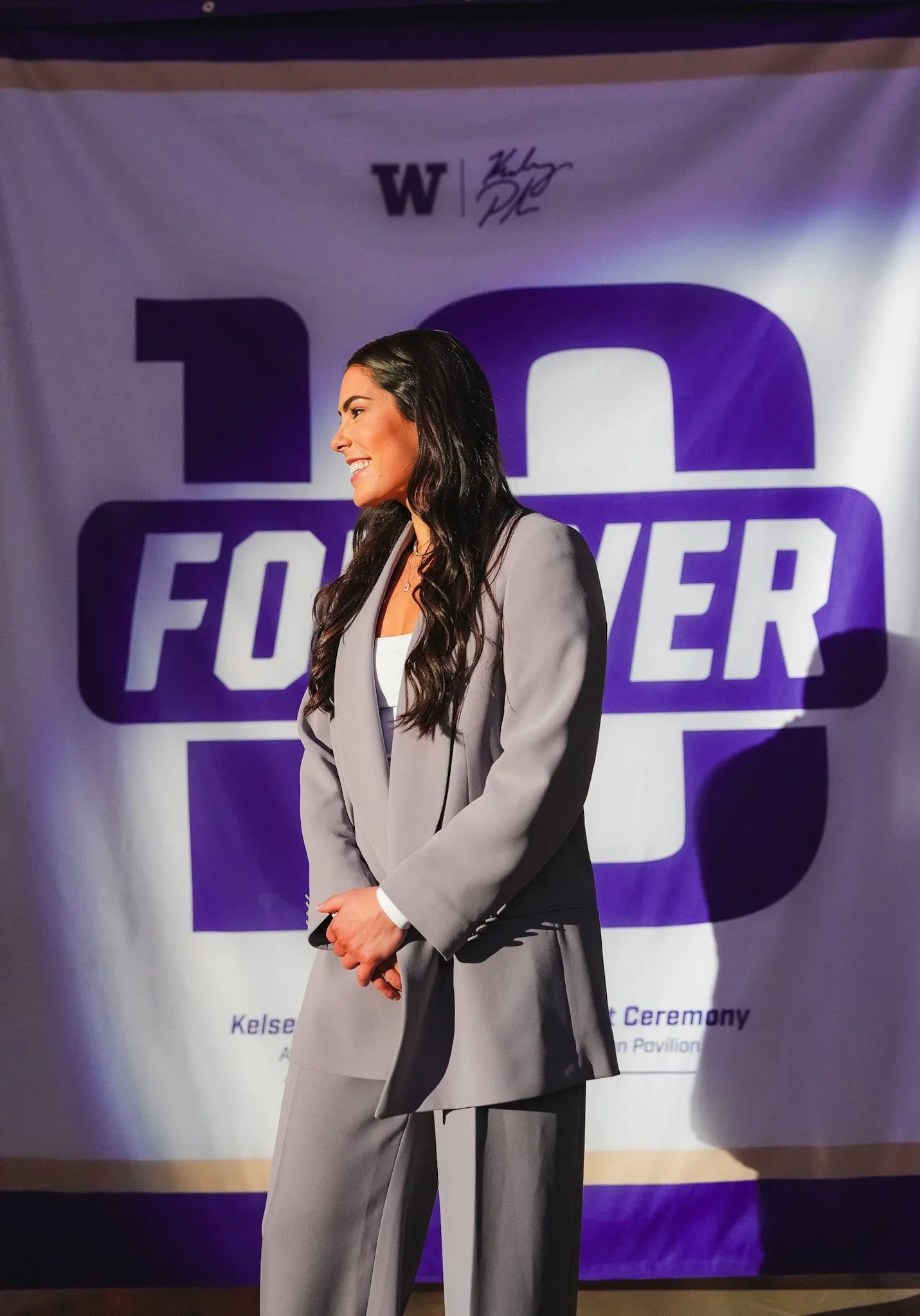 Kelsey Plum in front of the Forever 10 commemorative banner