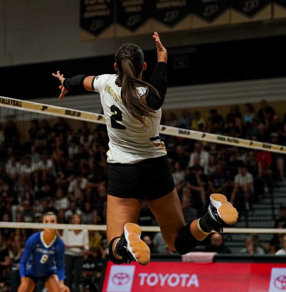Purdue outside hitter Chloe Chicoine attacking at the net, seen from behind