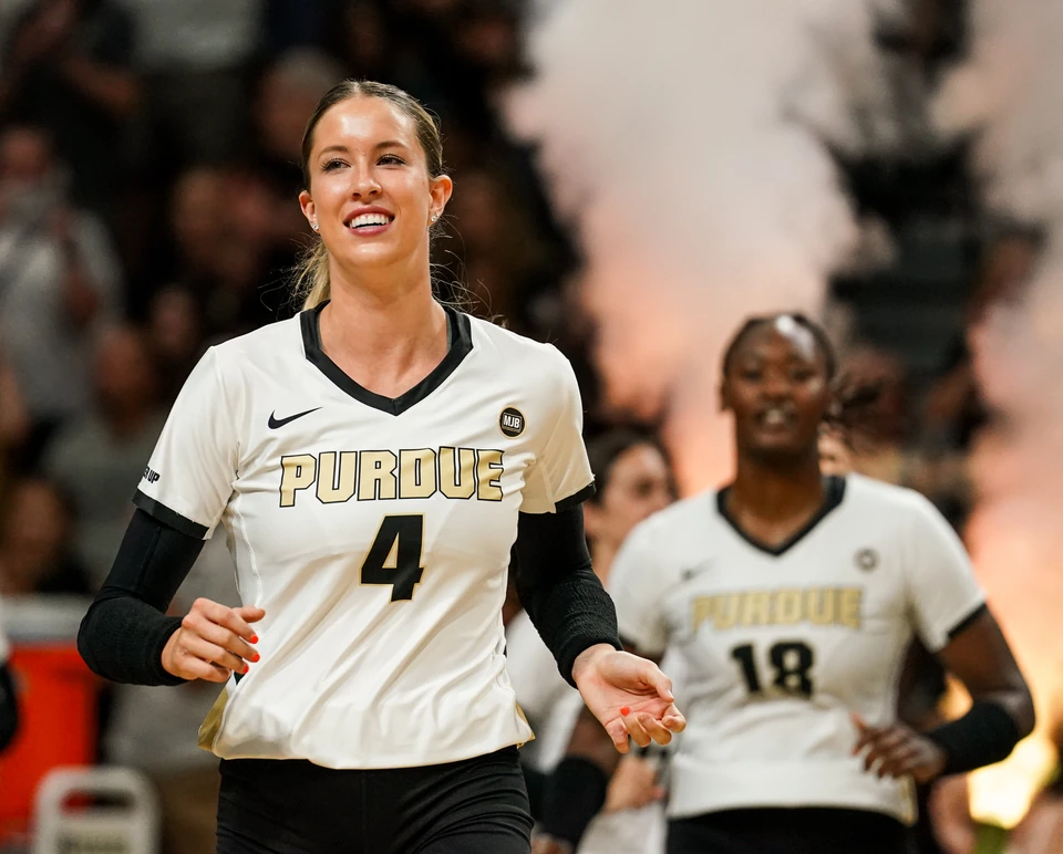 Purdue volleyball players run out onto the court through pyrotechnics